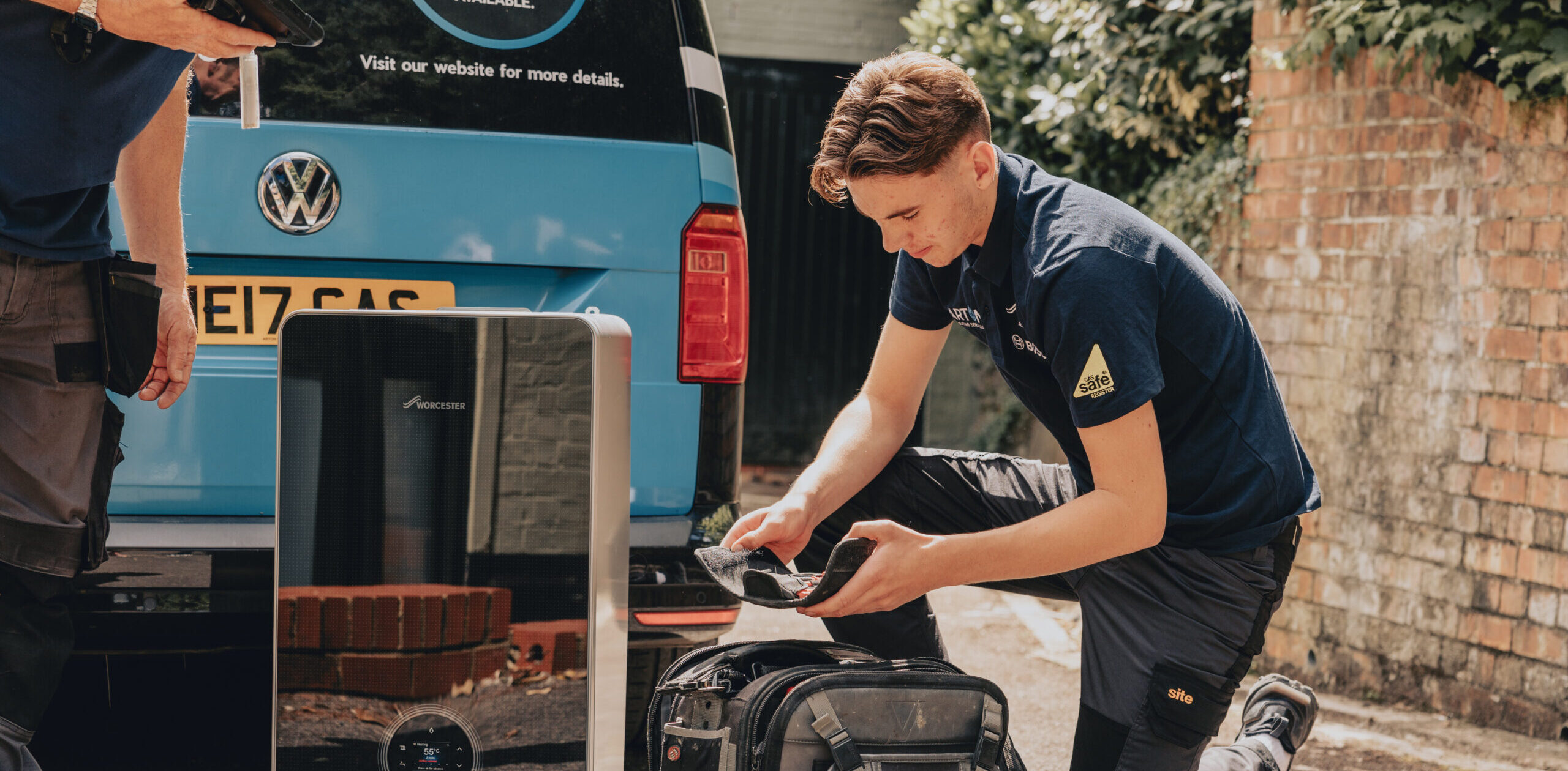 Heating engineer unloads new Worcester Bosch boiler from a van