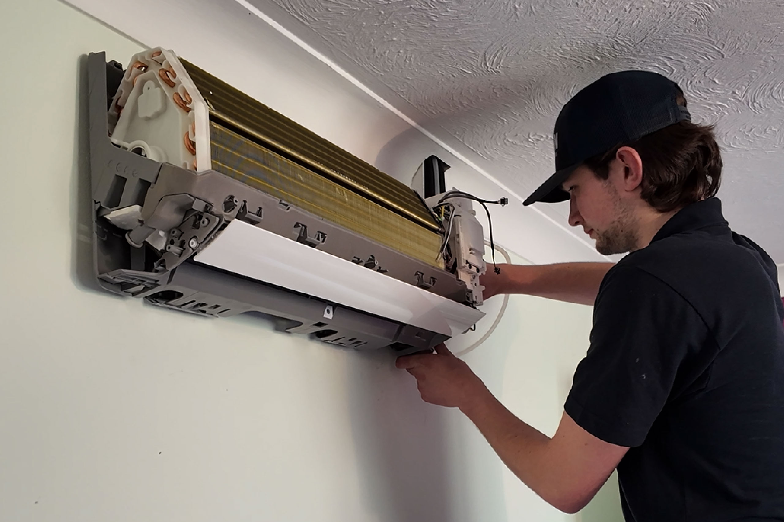 Arton employee fixing an aircon unit