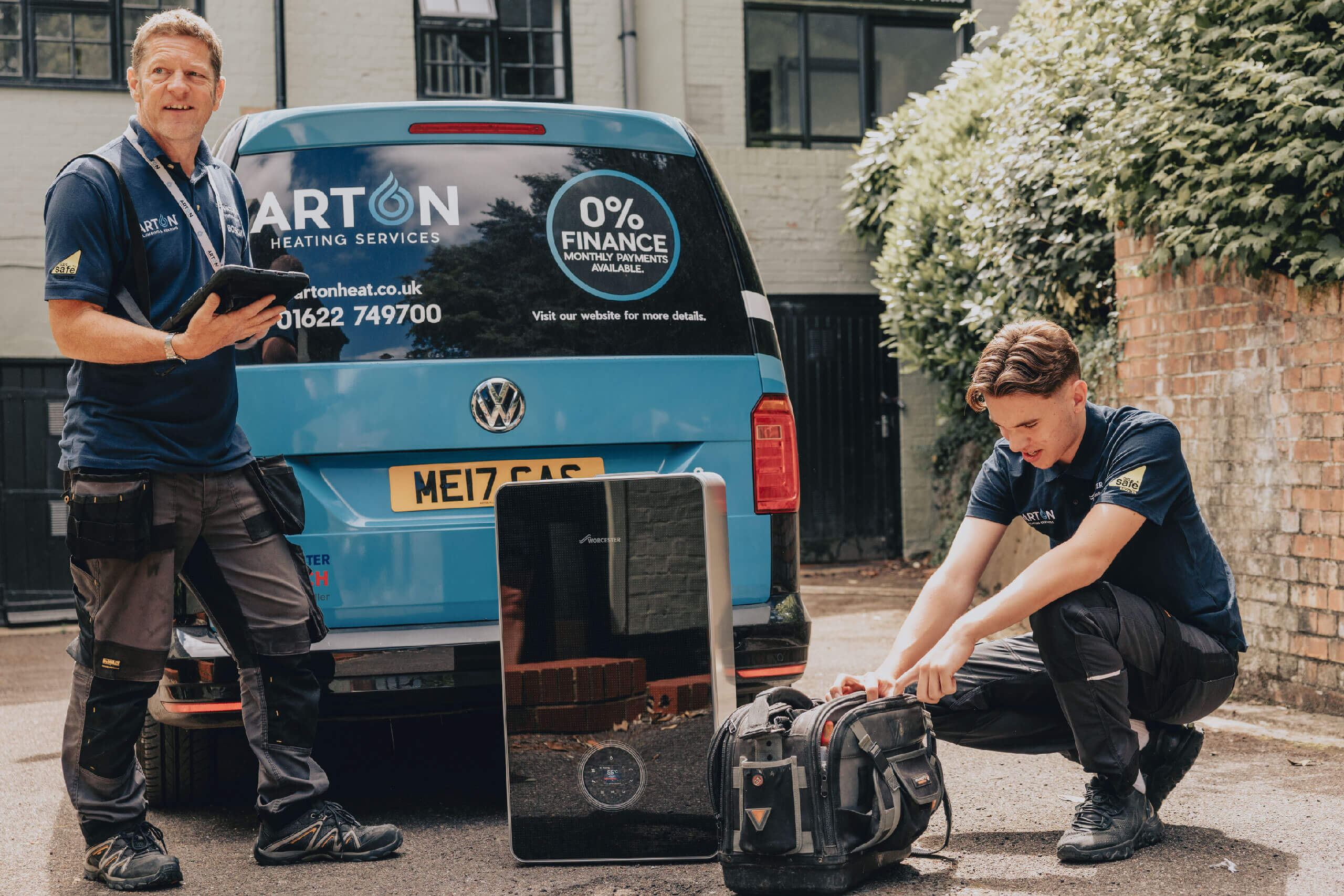 Engineers looking at a boiler in front of a van